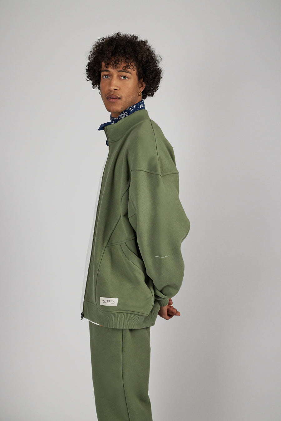Man wearing an oversized zipper sweat jacket in sage green