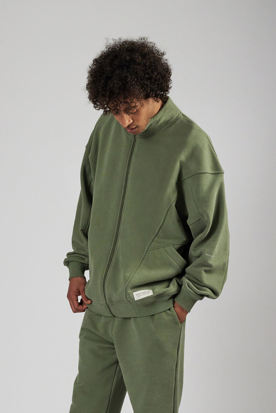 Man wearing an oversized zipper sweat jacket and sweatpants in color sage green
