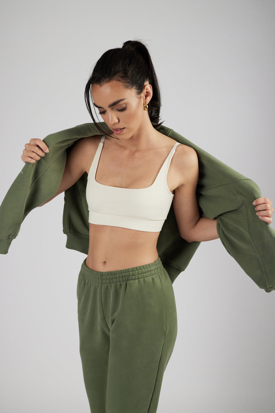 Woman wearing unisex sweatpants and crop top in color sage green