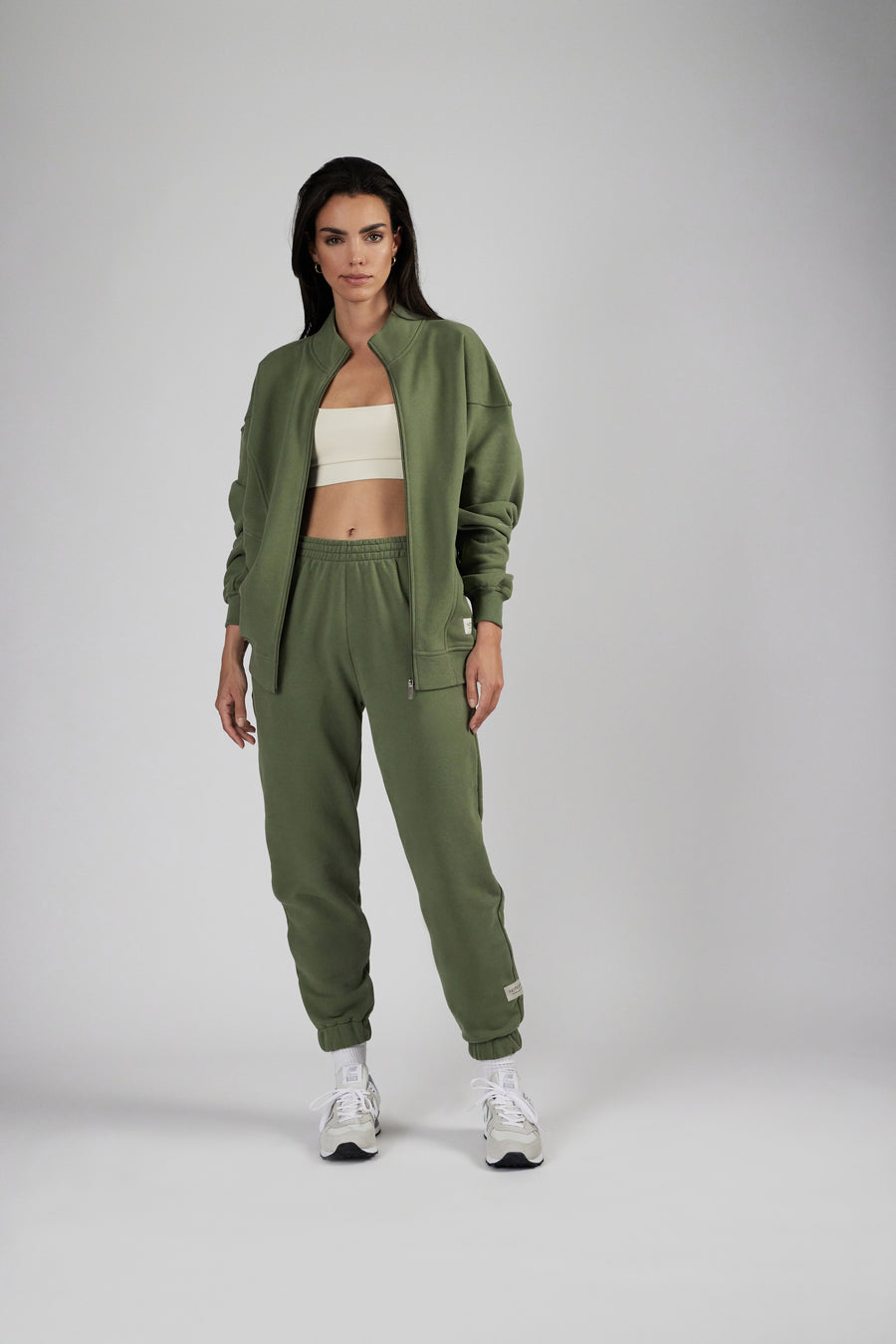 Woman wearing an oversized zipper sweat jacket and sweatpants in color sage green
