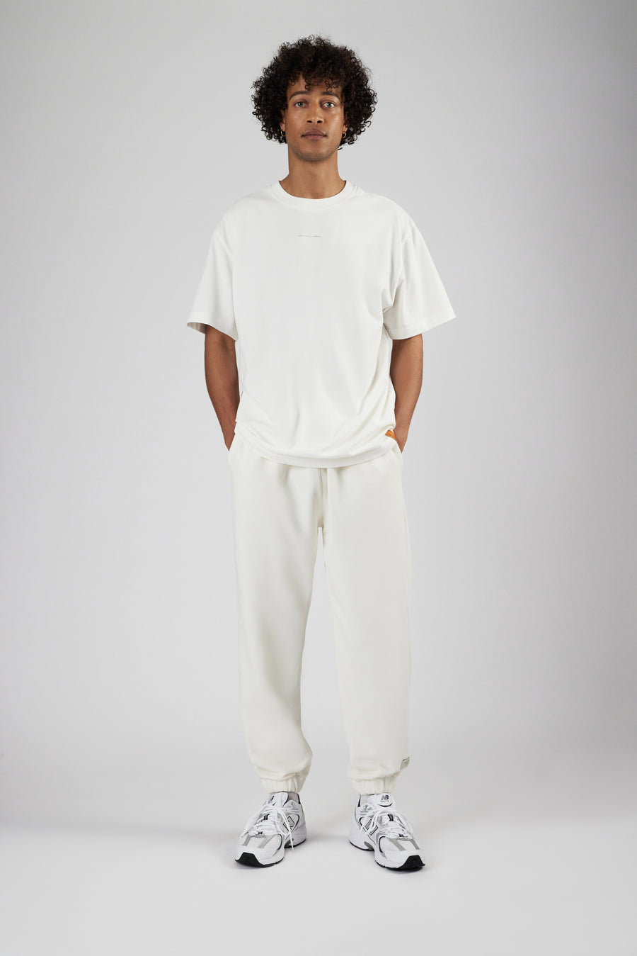 Man wearing sweatpants in color eggnog and oversized t-shirt