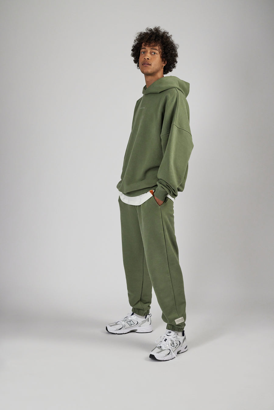 Man wearing unisex sweatpants and hoodie in color sage green