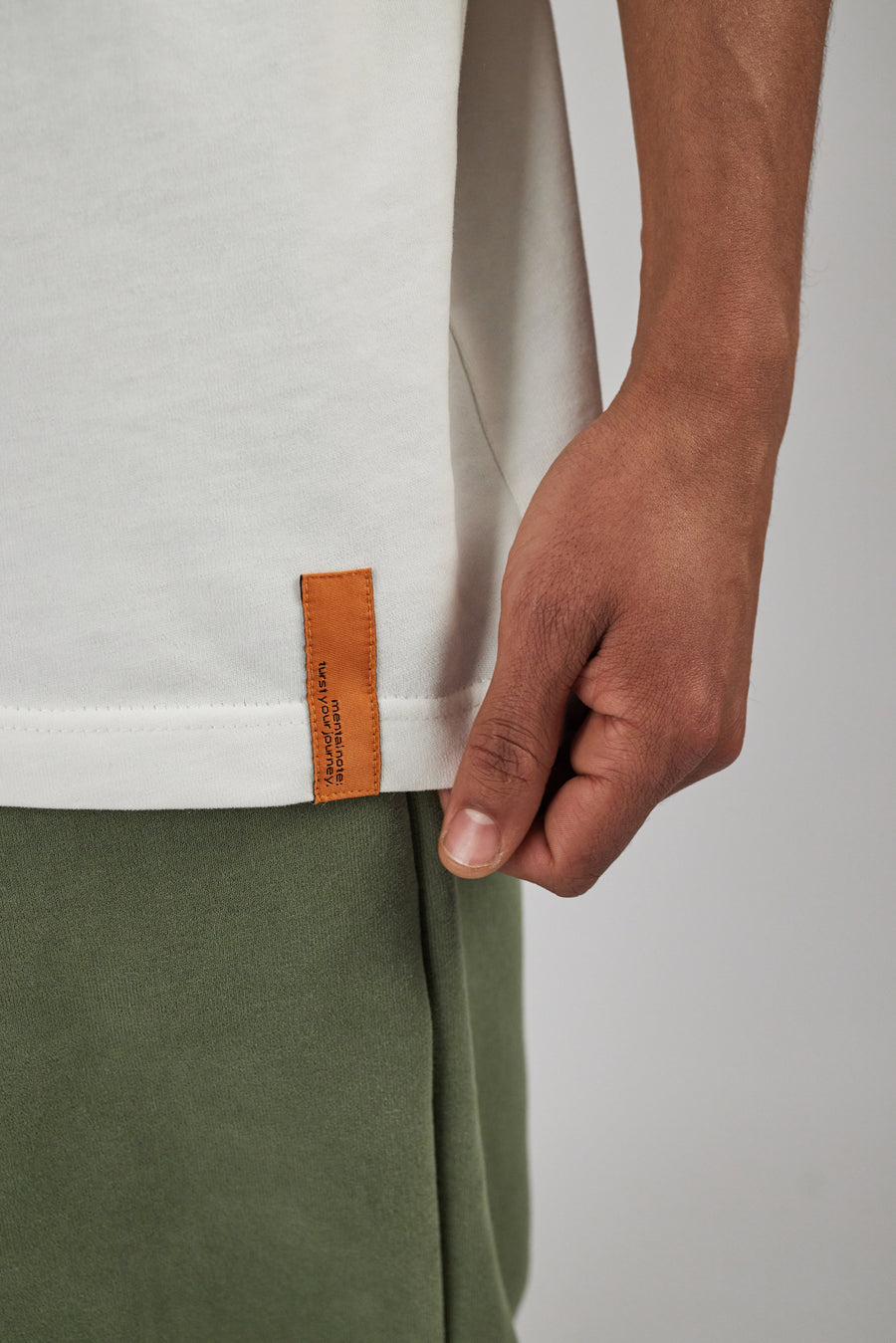 Close-up of an orange label stitched on the bottom of a t-shirt